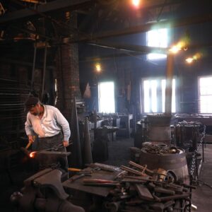man working inside shipsmith shop at mystic seaport museum